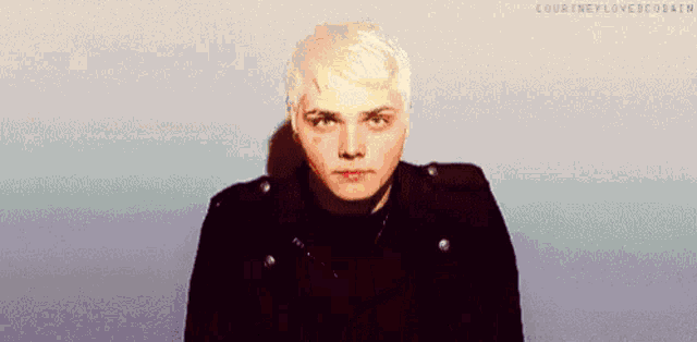a man with white hair is wearing a black jacket .