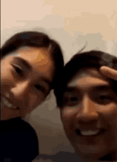 a man and a woman are posing for a picture and smiling for the camera .