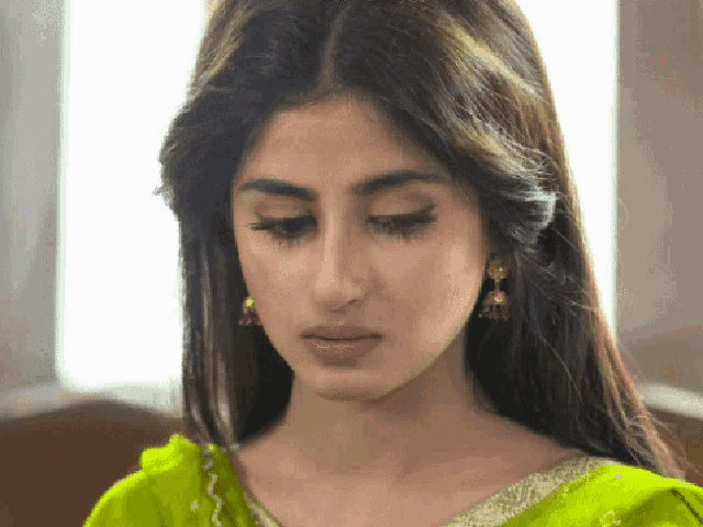 a close up of a woman wearing a green dress