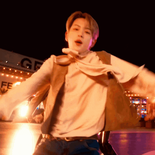 a man is dancing in front of a sign that says gf on it