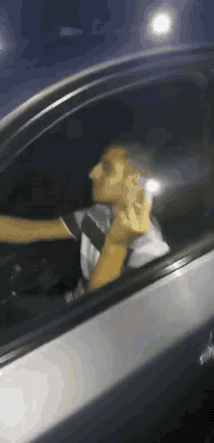 a man sitting in a car talking on a phone