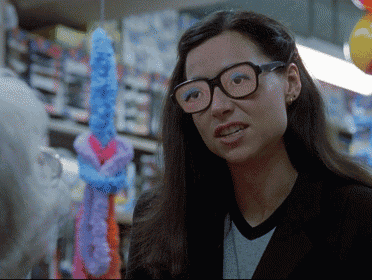 a woman wearing glasses is standing in front of a display of balloons