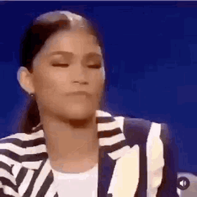 a woman in a striped jacket is making a face .