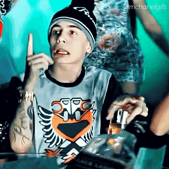a young man wearing a beanie and a shirt that says ' mc' on it
