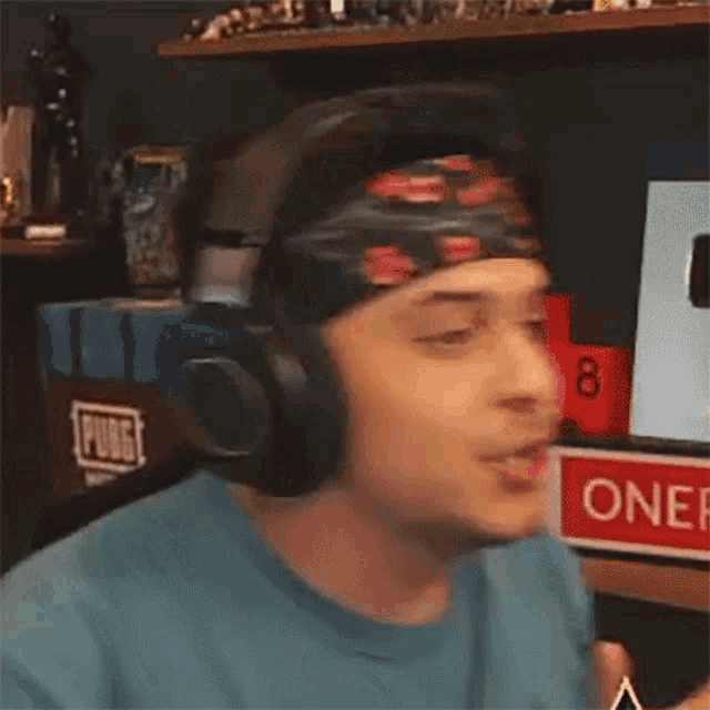 a man wearing headphones and a headband is blowing a kiss while playing a video game .
