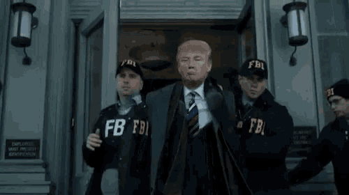 a man in a suit and tie is being escorted by a group of fbi agents .