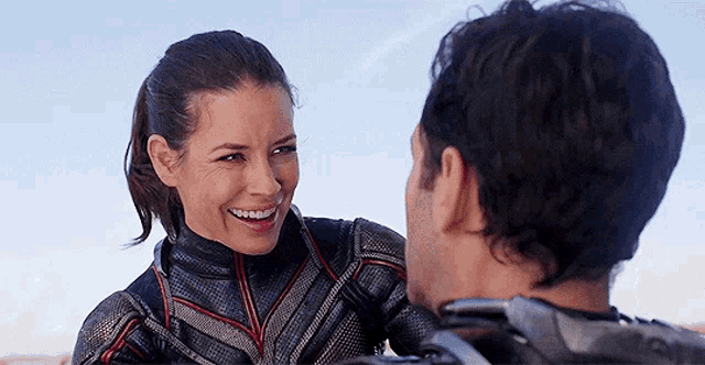 a man and a woman are smiling and looking at each other .