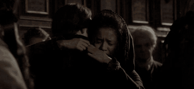 a group of people are hugging each other in a dark room