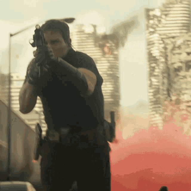 a man holding a gun in front of a burning city