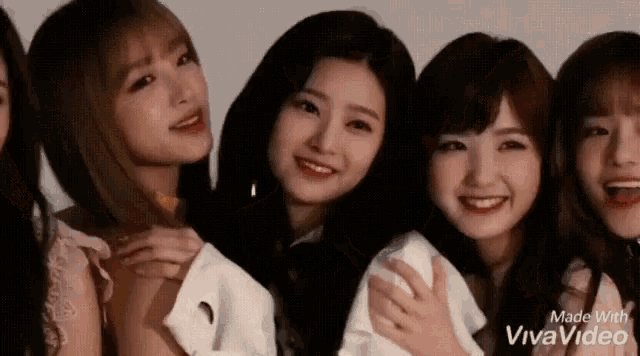 a group of young girls are posing for a picture together and smiling .