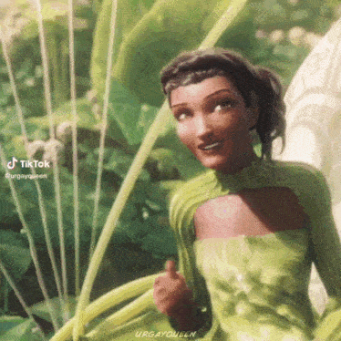 a woman in a green dress is standing in a garden .