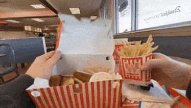 a person is taking french fries out of a box that says wendy 's on it
