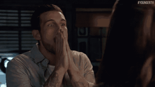 a man is covering his mouth with his hands while looking at a woman ..