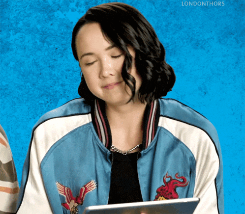 a woman wearing a blue jacket with an eagle embroidered on it is holding a tablet