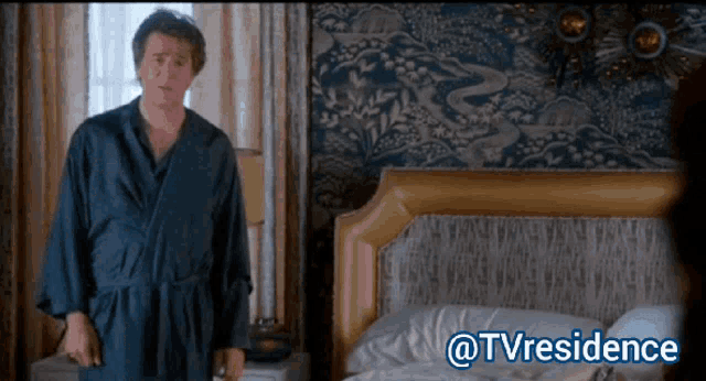 a man in a robe is standing in front of a bed with the hashtag @tvresidence