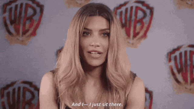 a woman says " and then i feel better " while standing in front of wb logos