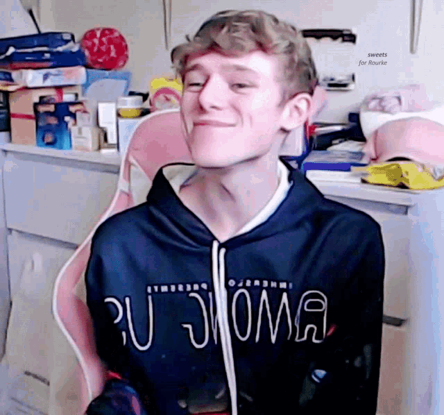 a young man wearing a black hoodie that says pu joma