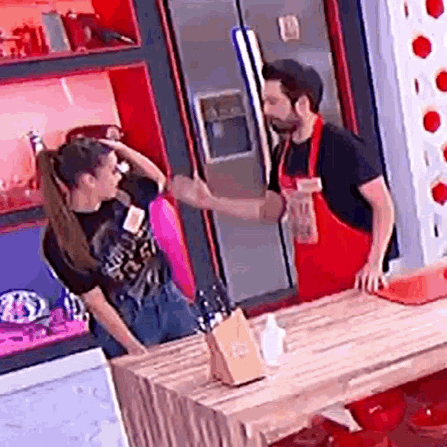a man and a woman are standing in a kitchen .