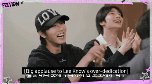 a man wearing a hat that says love applauds another man