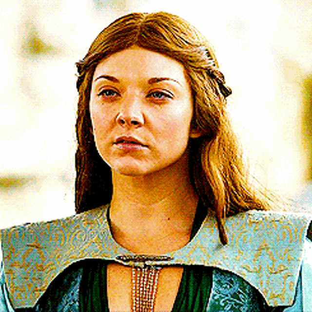 a close up of a woman 's face wearing a green dress
