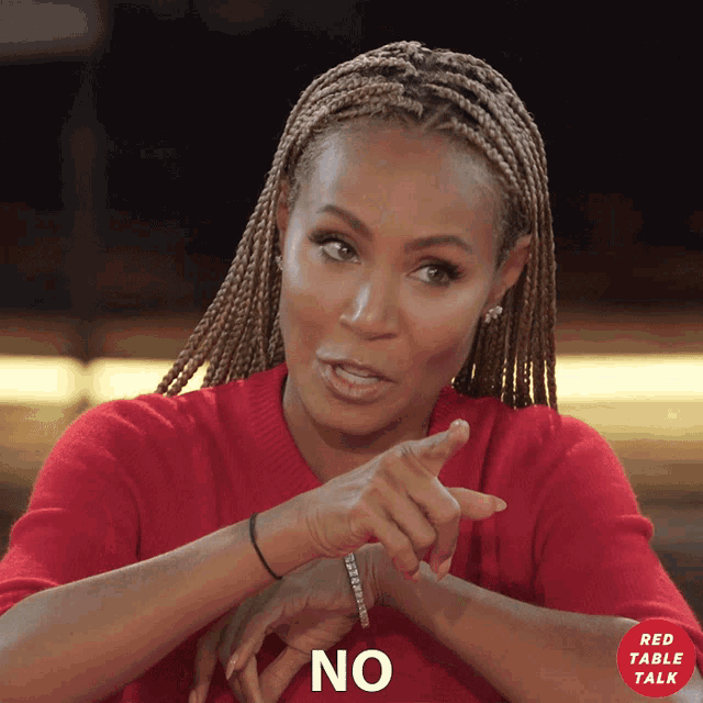 a woman in a red sweater says no with a red table talk logo in the background