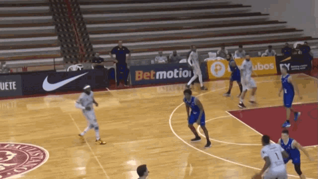 a basketball game is being played on a court with a bet motion banner in the background