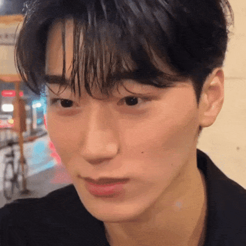 a close up of a young man 's face looking at the camera