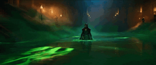 a person standing in a dark room with green smoke coming out of them