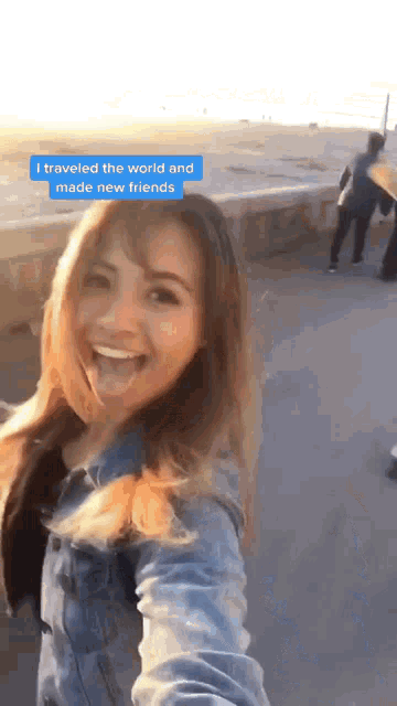 a woman taking a selfie with a blue sticker that says i traveled the world and made new friends