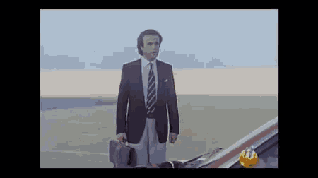 a man in a suit and tie holding a briefcase