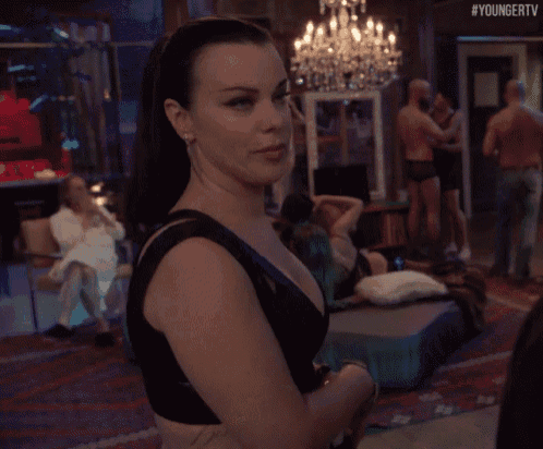 a woman in a black top is standing in a room with #youngertv written on the bottom right