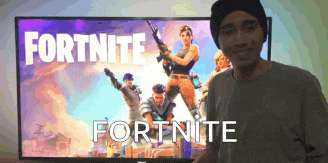 a man is standing in front of a screen that says fortnite on it