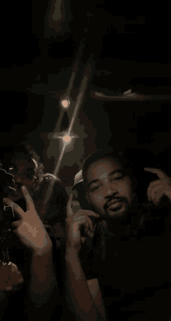 a group of people sitting in a dark room with a light shining on them