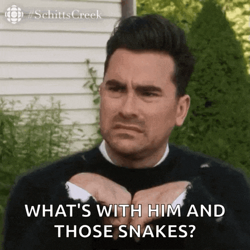 a man from schitt 's creek is making a funny face and asking what 's with him and those snakes