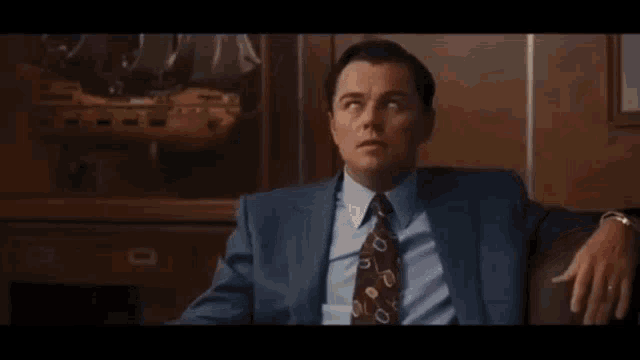 a man in a white shirt and tie is sitting in an office .