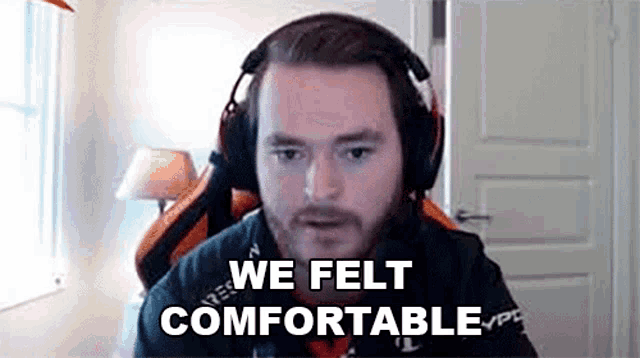 a man wearing headphones is sitting in front of a computer screen .