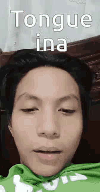 a close up of a person 's face with the words `` tongue ina '' on it .