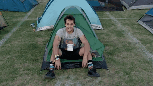 a man is sitting in a tent with a fly on a shirt on