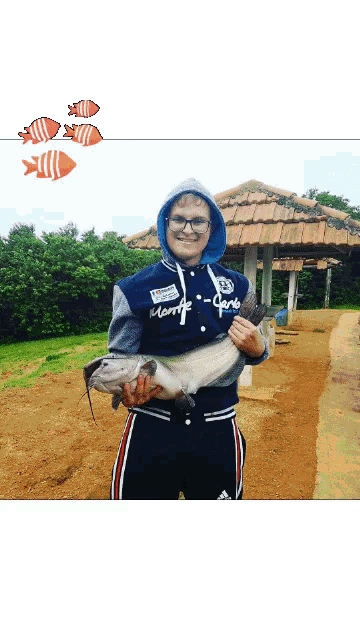 a man holding a fish with a hoodie that says monte carlo on it