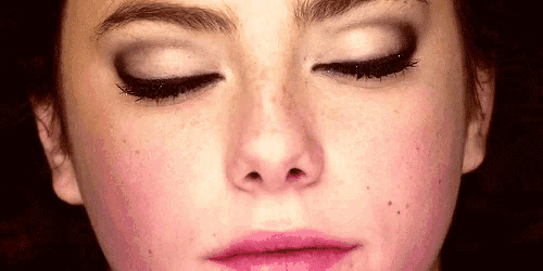 a close up of a woman 's face with her eyes closed