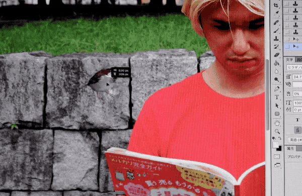 a man in a red shirt is reading a book in front of a computer