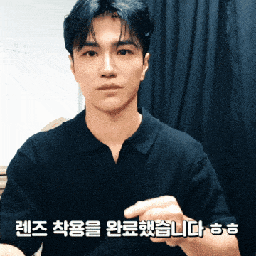 a man wearing a black shirt with korean writing on the bottom