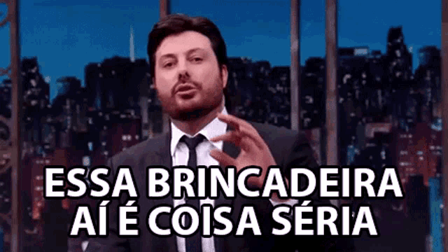 a man in a suit and tie is making a funny face while talking on a television show .