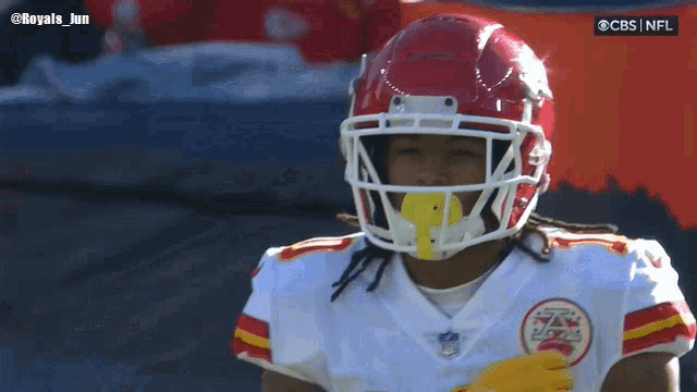 a football player wearing a red helmet with a yellow stripe on the side