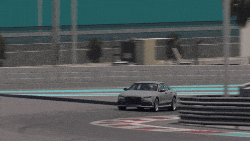 a silver audi is driving down a race track