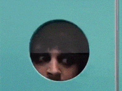 a close up of a person 's face through a hole in a door
