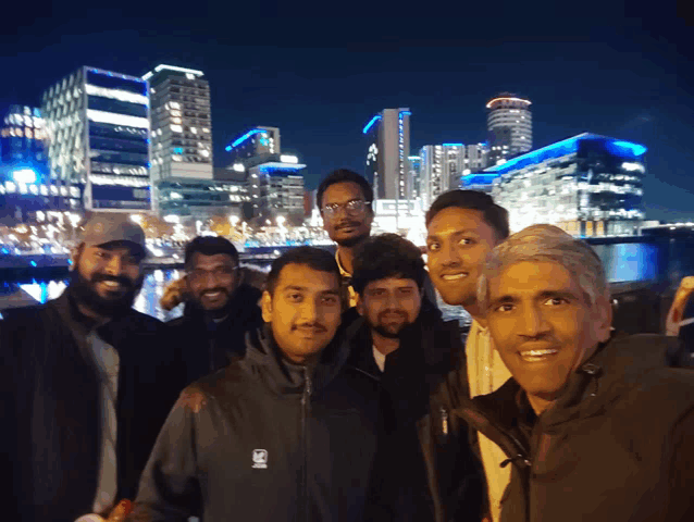a group of men are posing for a picture with one wearing a vest that says ' sd ' on it