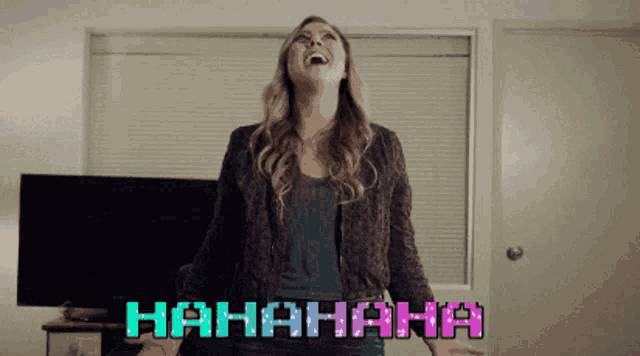 a woman laughs in front of a screen that says '  hahaha '