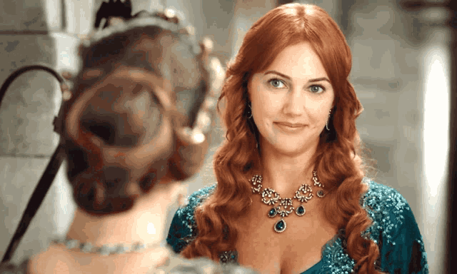a woman with red hair is wearing a blue dress