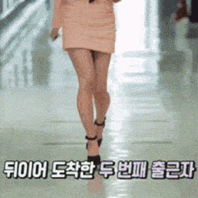 a woman in a pink skirt is walking down a hallway with chinese writing on the bottom